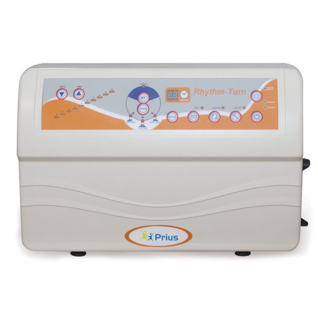 The Prius Rhythm Turn Control Unit for LAL Mattress System is a white device with an orange and blue control panel labeled Rhythm-Turn, featuring buttons, icons, a digital display, and adjustable comfort settings for patient care.